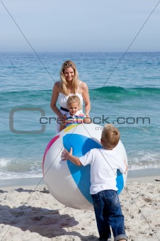 Caring mother and her children playing with a ball
