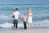 Happy family walking on the sand 