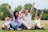 Happy family of five having fun by raising hands