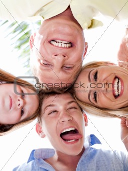 Happy family joining their heads together and moking fun