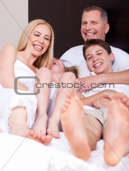 Loving family of four having fun and looking at you
