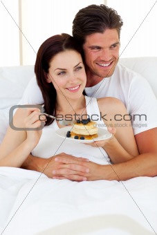 Romantic couple drinking orange juice lying in the bed