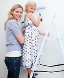 Mother and her little girl painting a room