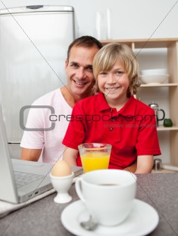 Happy father and his son having breakfast 
