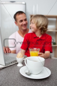 Jolly father and his son having breakfast 