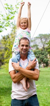 Joyful father giving his daughter piggy-back ride 