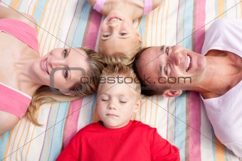 Cheerful family sleeping lying on the grass