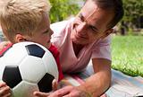Close-up of an attentive father and his son holding a soccer bal