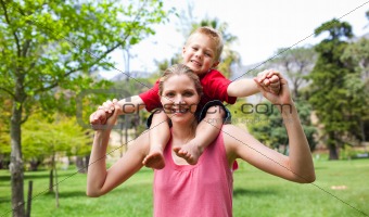 Happy mother giving her son a piggyback ride