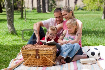 Happy family reading in a park
