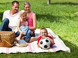 Happy parents and children picnicing in the park 