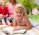 Close-up of a little girl reading at a picnic 