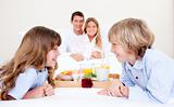 Cheerful family having breakfast sitting on bed