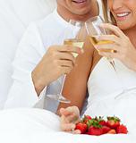 Close-up of a couple drinking Champagne with strawberries 
