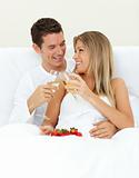 Intimate couple drinking Champagne with strawberries 