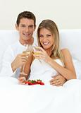 Romantic couple drinking Champagne with strawberries