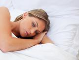 Worried woman lying on her bed 