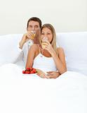 Loving couple drinking Champagne with strawberries 