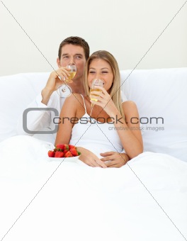 Loving couple drinking Champagne with strawberries 