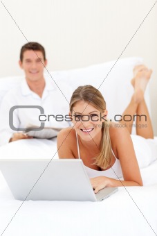 Smiling couple relaxing on their bed 