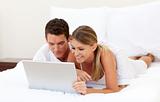 Smiling couple using a laptop 