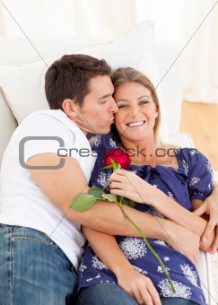 Affectionate man kissing his wife lying on sofa