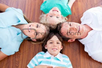 Smiling family lying in circle on the floor