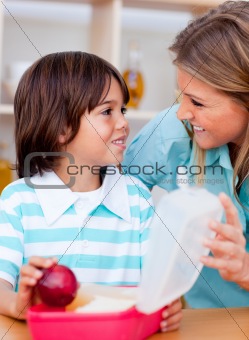 Joyful little boy and his mother preparing his snack