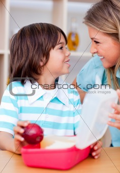Cute little boy and his mother preparing his snack