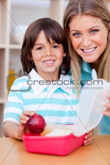 Cheerful little boy and his mother preparing his snack