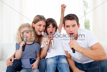 Portrait of a lively family singing through microphone