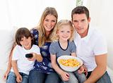Loving family watching television sitting on sofa
