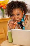 Young Woman Drinking Beverage and Using Laptop