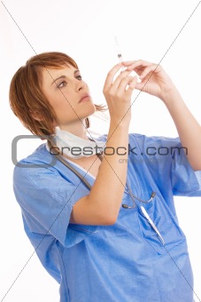 Young female nurse checking filled syringe