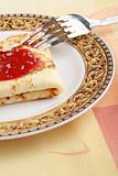 delicious pancake with red jam in a plate