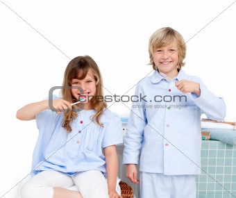 Smiling brother and siter brushing their teeth 