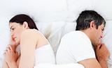 Upset couple sleeping in their bed separately 
