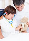 Caring father and his sick son playing with a stethoscope