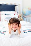 Cheerful little boy listening music with headphones on