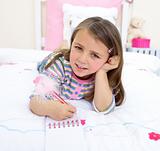 Beautiful little girl lying on her bed 