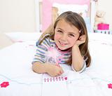 Little girl writing on a notebook lying on her bed