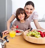 Cheerful mother and her child having breakfast