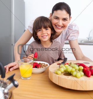 Cheerful mother and her child having breakfast
