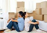 Tired couple relaxing while moving house