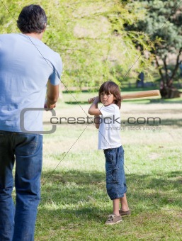 Jolly little boy playing baseball with his father