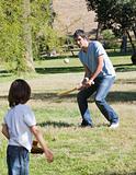 Athletic father playing baseball with his son
