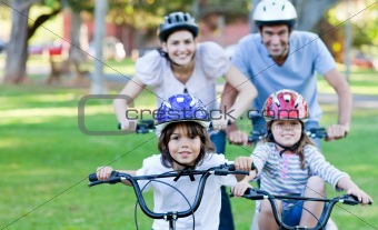 Adorable family riding bikes in a park
