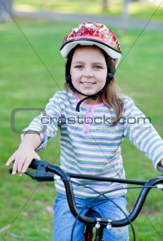 Joyful little girl riding a bike 