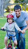 Little girl learning to ride a bike with her father