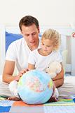 Father and daugther looking at a terrestrial globe
